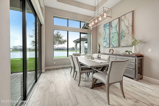 3882 Durksly Dr, Melbourne, FL 32940 - dining space with light wood-style floors, a water view, and baseboards