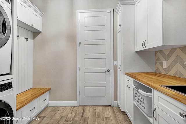3882 Durksly Dr, Melbourne, FL 32940 - mudroom featuring stacked washer / dryer, light wood-style flooring, and baseboards
