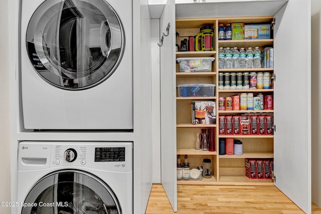 3882 Durksly Dr, Melbourne, FL 32940 - clothes washing area featuring laundry area, wood finished floors, and stacked washer and clothes dryer