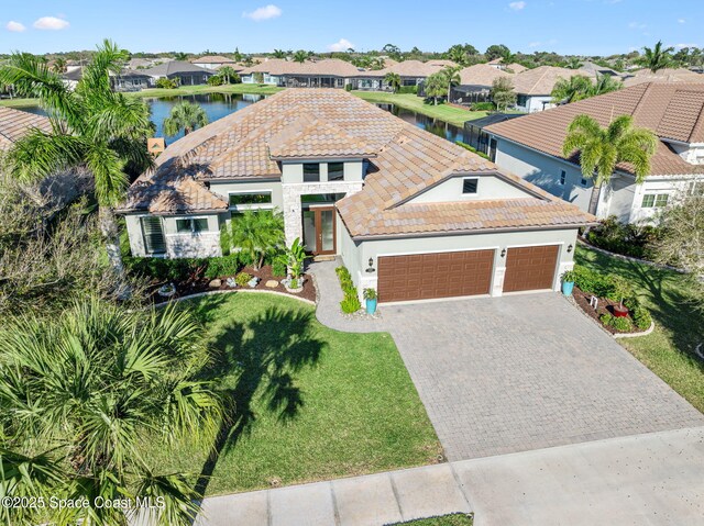 3882 Durksly Dr, Melbourne, FL 32940 - mediterranean / spanish home featuring an attached garage, a tile roof, decorative driveway, a residential view, and stucco siding
