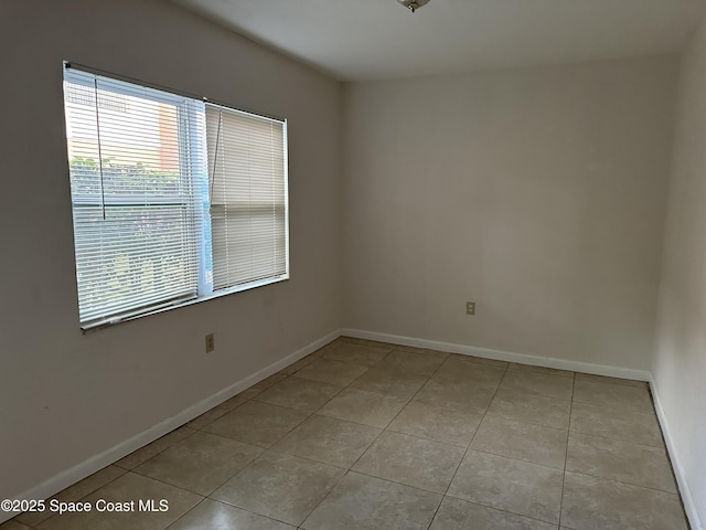 unfurnished room featuring baseboards and light tile patterned floors