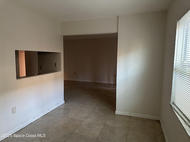 spare room featuring baseboards and tile patterned floors