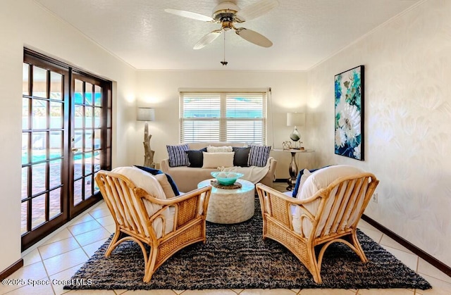 sitting room with ceiling fan, crown molding, light tile patterned flooring, and baseboards