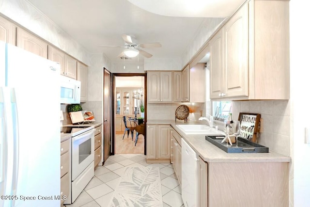 kitchen featuring tasteful backsplash, light countertops, a ceiling fan, a sink, and white appliances