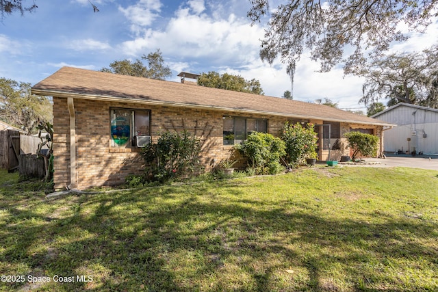 ranch-style home featuring fence, a front lawn, and brick siding