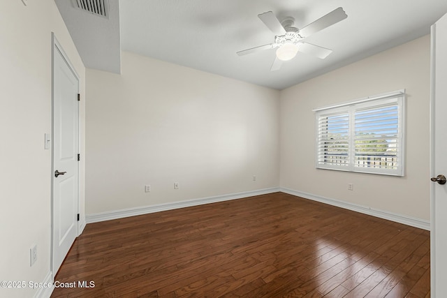 empty room with visible vents, dark wood finished floors, baseboards, and ceiling fan