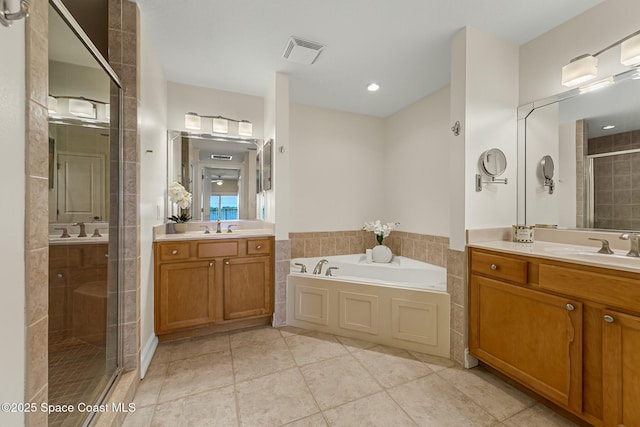 full bath featuring a garden tub, a stall shower, two vanities, and a sink