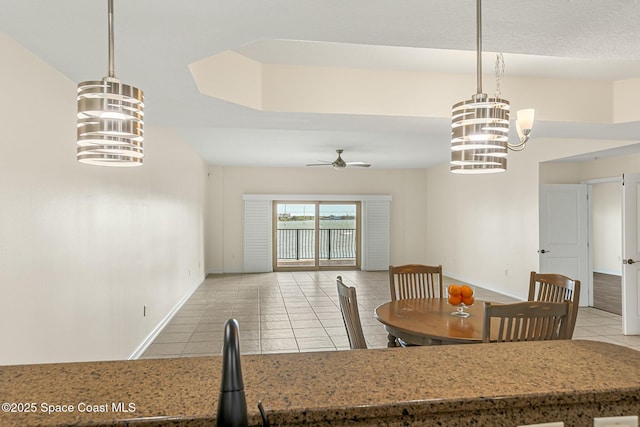 dining space featuring light tile patterned floors, ceiling fan with notable chandelier, and baseboards