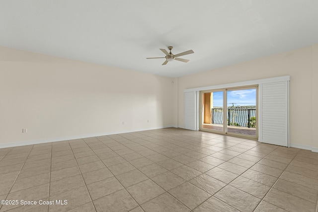 spare room with baseboards, a ceiling fan, and light tile patterned flooring