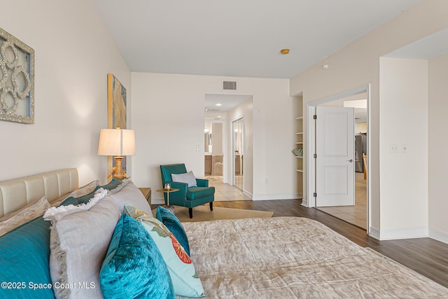 29 Riverside Dr Unit 402, Cocoa, FL 32922 - bedroom featuring wood finished floors, connected bathroom, and freestanding refrigerator