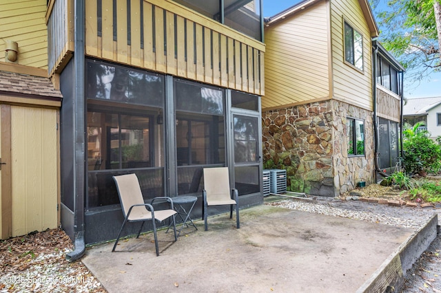 view of patio featuring a sunroom and central air condition unit