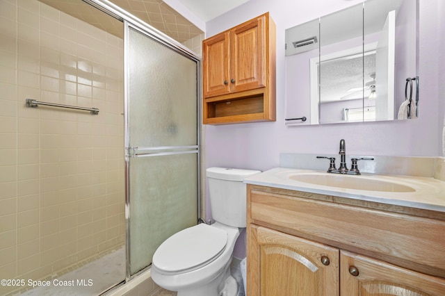 bathroom featuring a stall shower, visible vents, vanity, and toilet