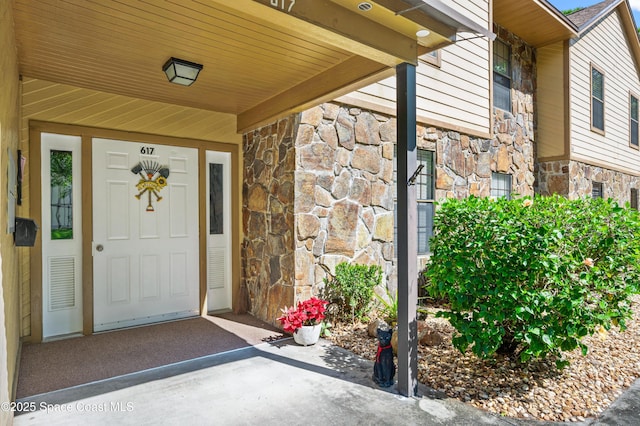 doorway to property with stone siding