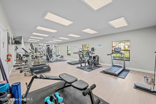 gym with a wealth of natural light, baseboards, and wood finished floors