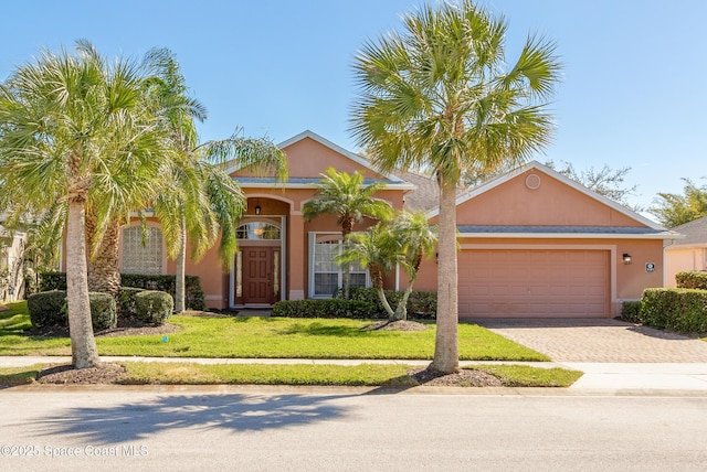 view of front facade featuring stucco siding, decorative driveway, a garage, and a front lawn