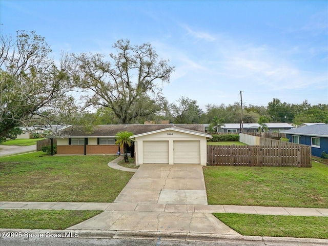 view of front of home featuring an attached garage, fence, concrete driveway, stucco siding, and a front lawn