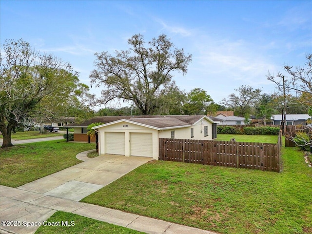 view of front facade with stucco siding, concrete driveway, an attached garage, a front yard, and fence