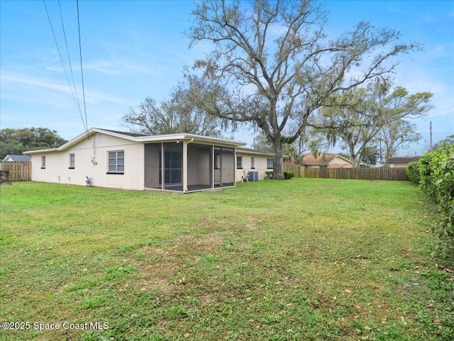 view of yard with a sunroom, a fenced backyard, and central air condition unit