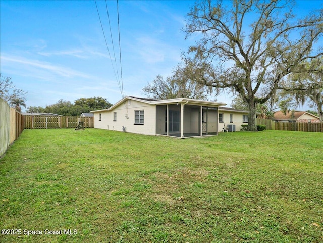 back of property featuring a sunroom, a fenced backyard, and a lawn