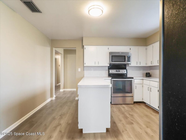 kitchen featuring visible vents, light wood-style flooring, appliances with stainless steel finishes, light countertops, and white cabinetry