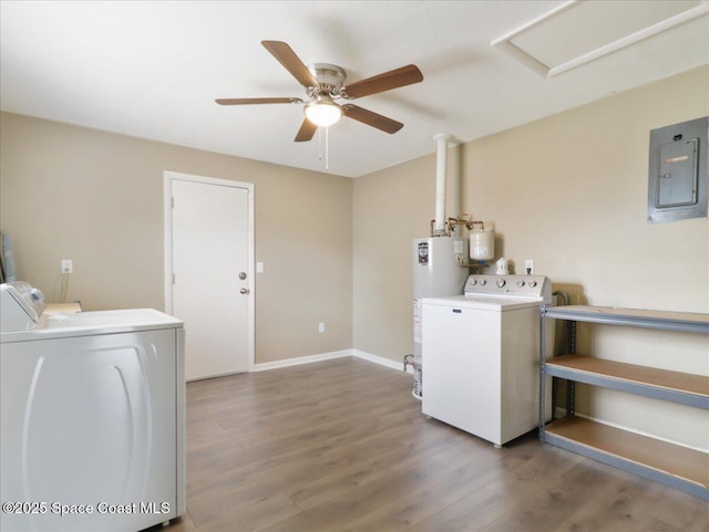 clothes washing area with gas water heater, washer and clothes dryer, wood finished floors, laundry area, and electric panel