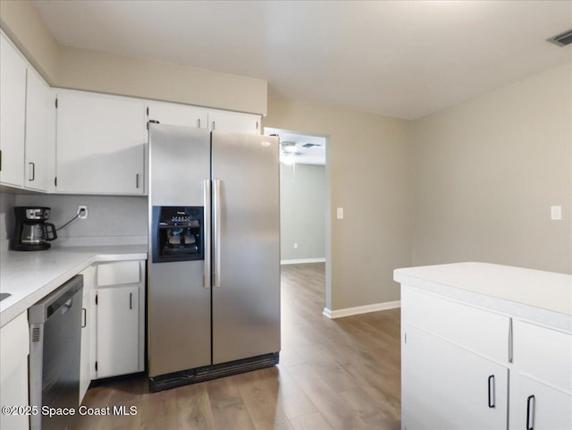 kitchen featuring stainless steel appliances, light countertops, white cabinetry, and wood finished floors