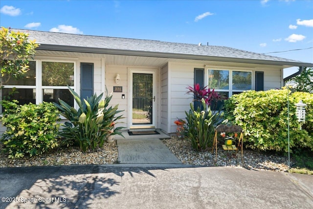 entrance to property featuring a shingled roof