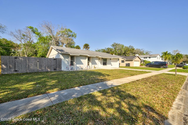 view of front of home with an attached garage, fence, a gate, stucco siding, and a front lawn