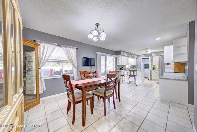 dining area featuring light tile patterned flooring, a textured ceiling, baseboards, and an inviting chandelier