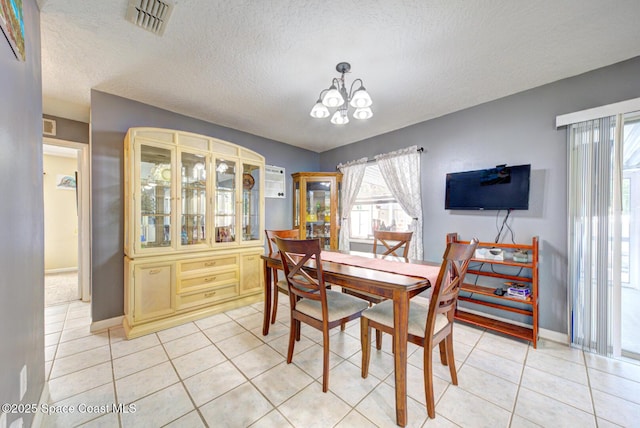 dining area featuring light tile patterned floors, a wealth of natural light, visible vents, and a notable chandelier