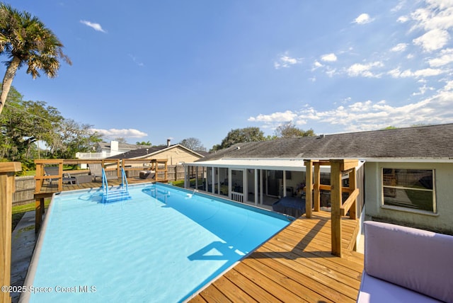 view of swimming pool with a fenced in pool, a sunroom, a fenced backyard, and a wooden deck