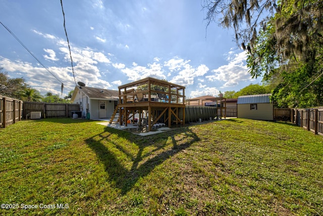 back of house with an outbuilding, a yard, a shed, a fenced backyard, and a wooden deck