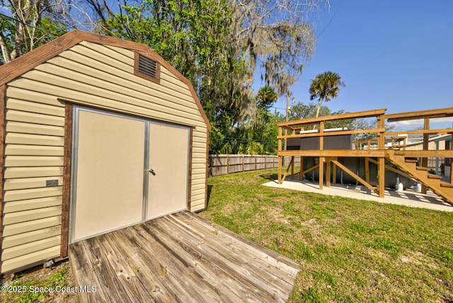 view of shed with a fenced backyard and stairway