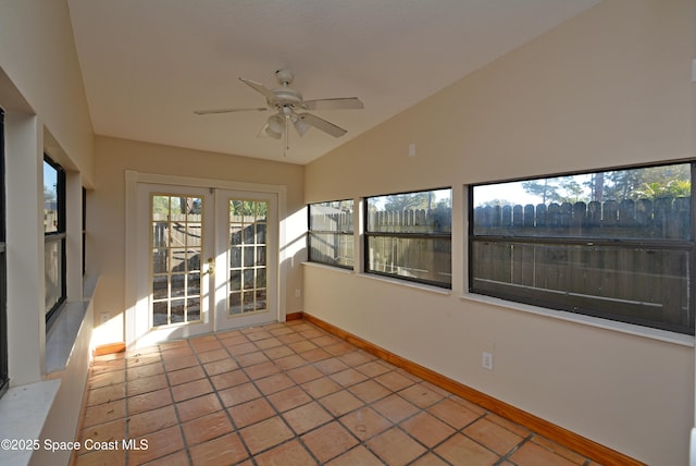 unfurnished sunroom featuring vaulted ceiling, a ceiling fan, and french doors