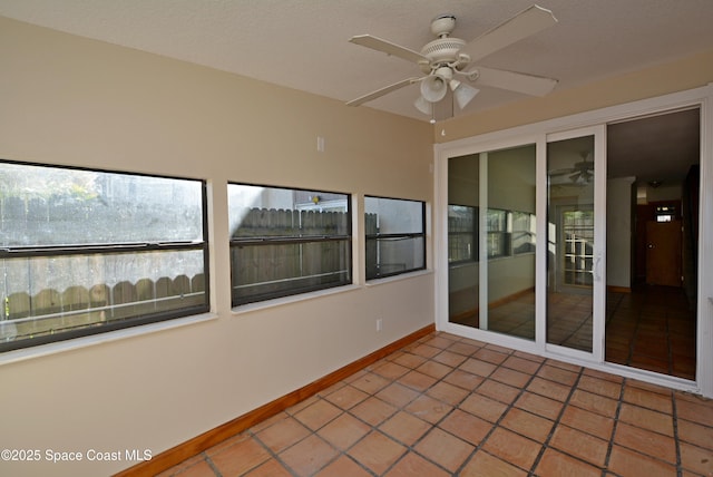 unfurnished sunroom featuring a ceiling fan