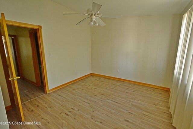 spare room with light wood finished floors, baseboards, and a ceiling fan