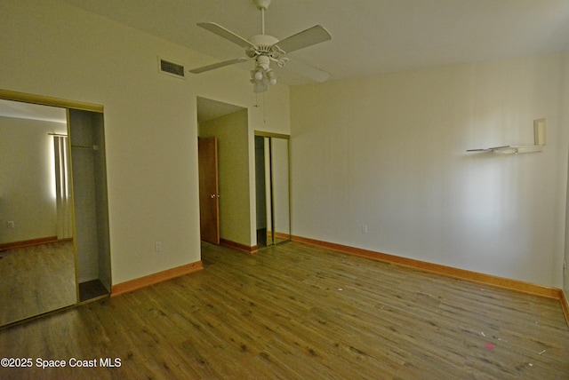 unfurnished room featuring a ceiling fan, visible vents, baseboards, and wood finished floors