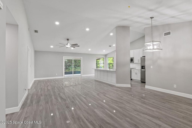 unfurnished living room with ceiling fan, light wood-type flooring, visible vents, and baseboards