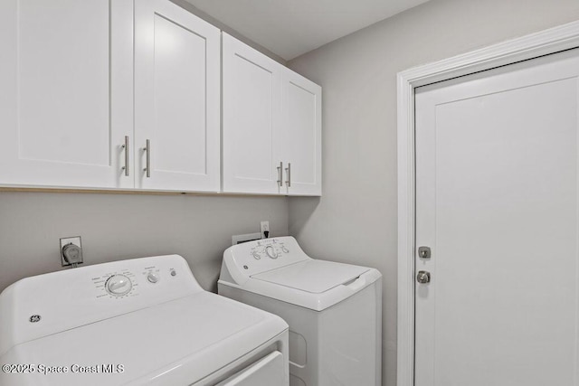 washroom featuring cabinet space and separate washer and dryer