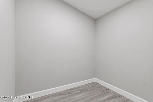 empty room with light wood finished floors and baseboards