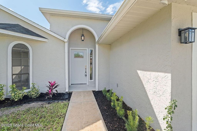 doorway to property featuring stucco siding