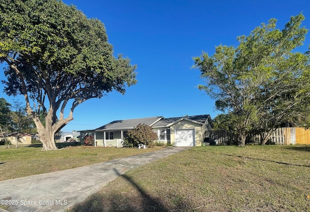 ranch-style home featuring an attached garage, driveway, a front yard, and fence