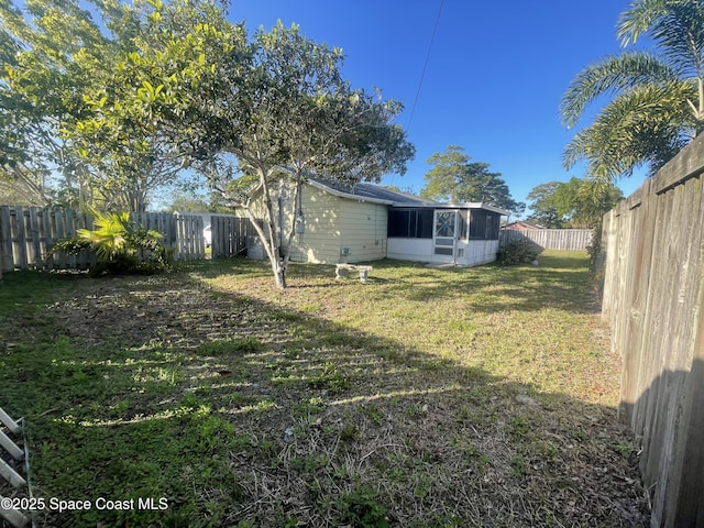 view of yard with a sunroom and a fenced backyard