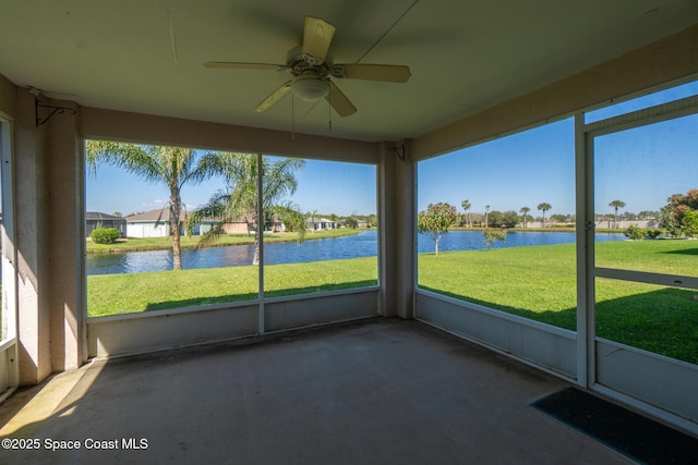 unfurnished sunroom featuring ceiling fan and a water view