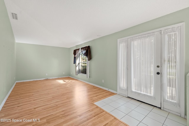 entryway featuring baseboards, visible vents, and light wood finished floors