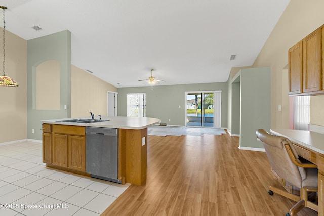 kitchen featuring a sink, brown cabinets, light countertops, and stainless steel dishwasher