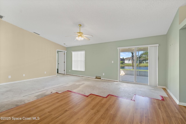 unfurnished room with visible vents, vaulted ceiling, baseboards, and ceiling fan