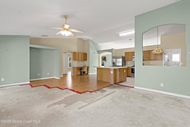 unfurnished living room featuring arched walkways, baseboards, a ceiling fan, vaulted ceiling, and concrete floors