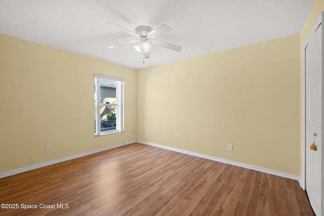 spare room with light wood-style flooring, baseboards, and ceiling fan