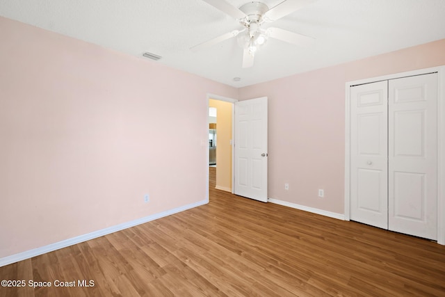 unfurnished bedroom featuring light wood finished floors, visible vents, and baseboards